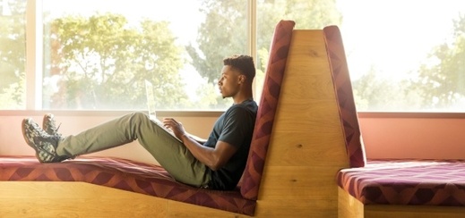 student-sitting-on-bench-writing-cover-letter-on-laptop